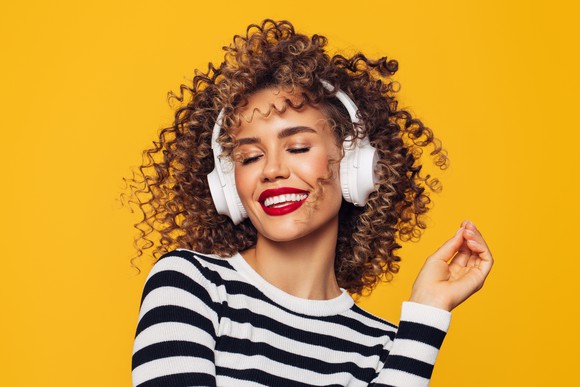 Woman listening to music on headphones. 