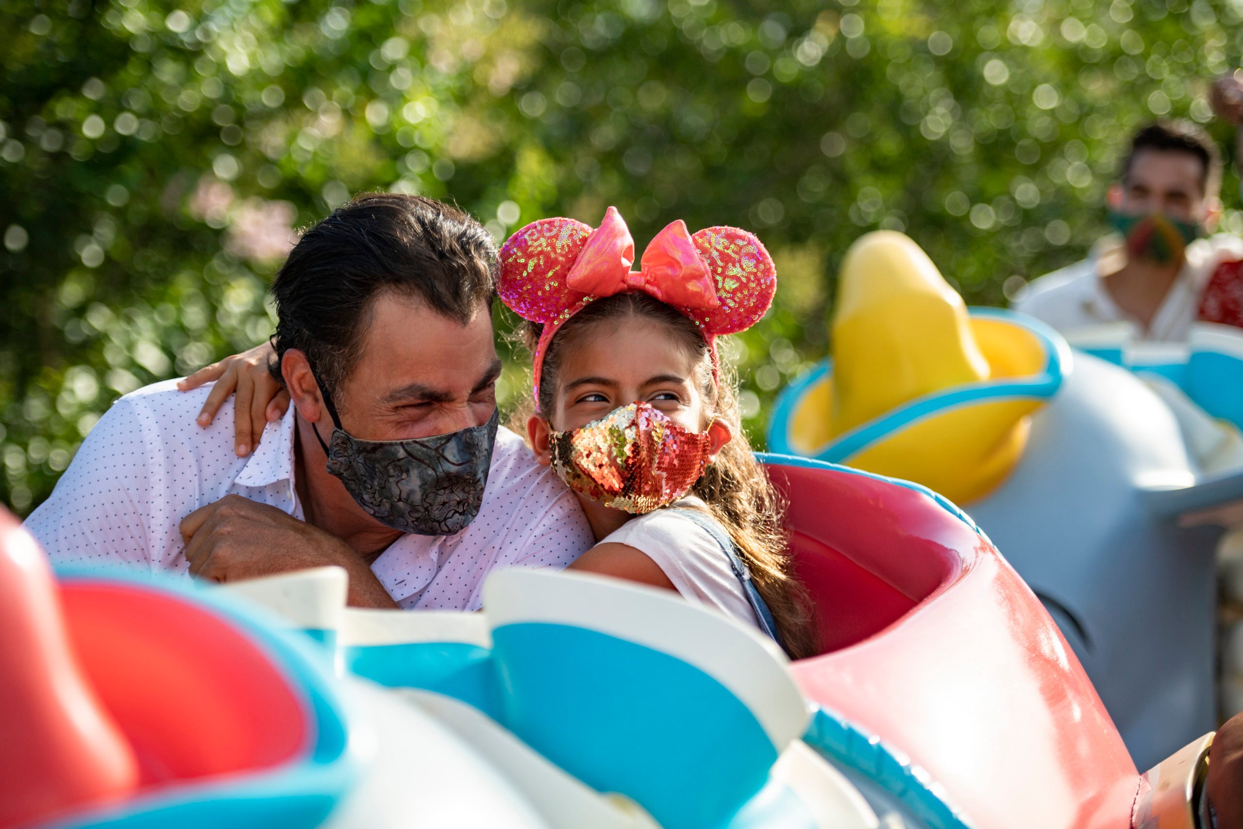 A dad and daughter enjoy a Disney attraction.