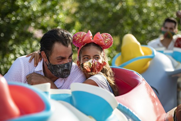 A dad and daughter enjoy a Disney attraction.