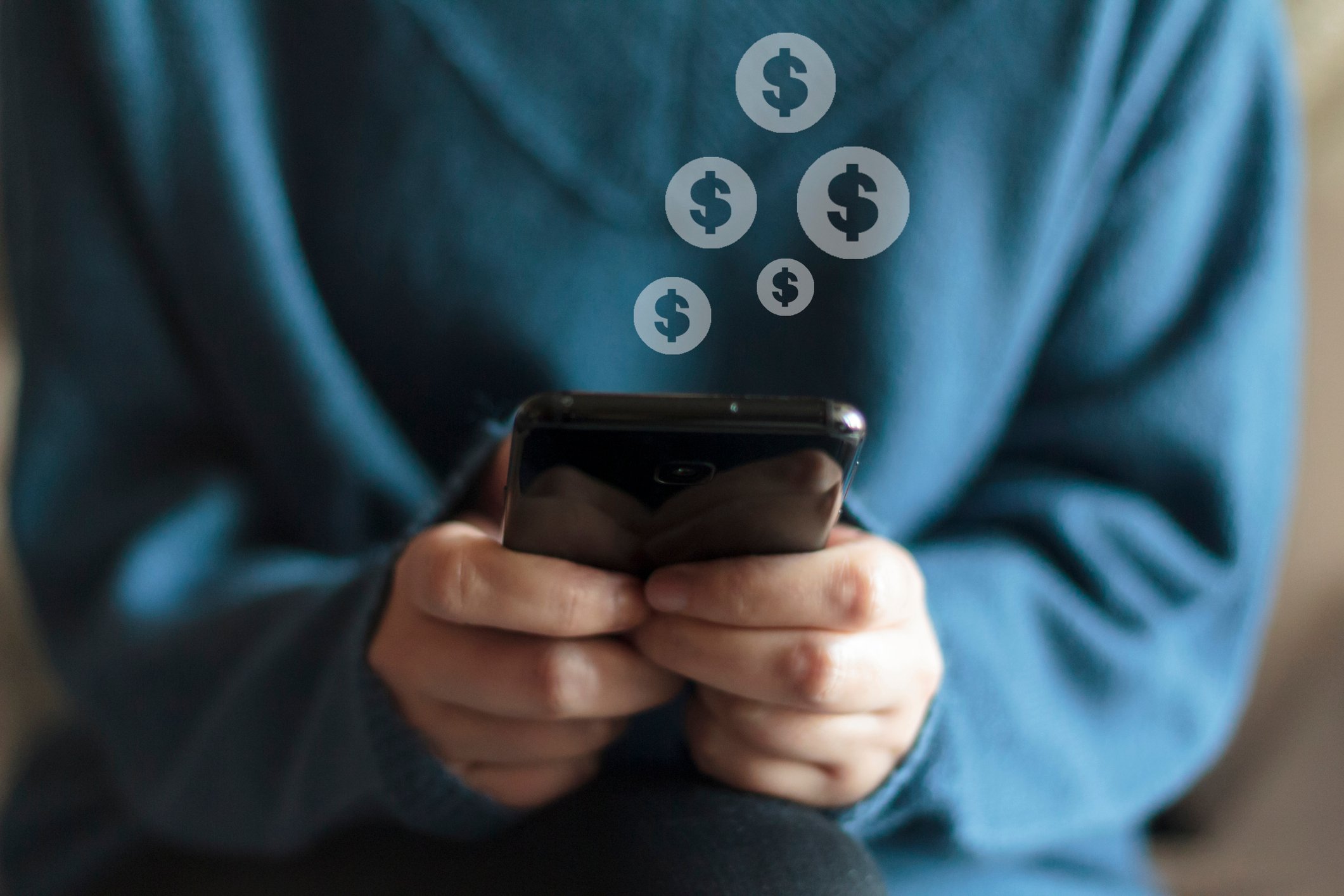 Woman holding a smartphone with images of dollar signs appearing over the phone