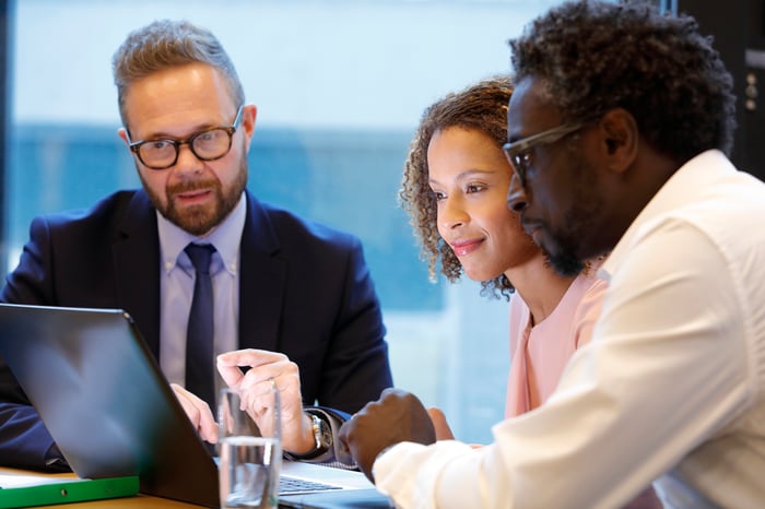 A couple consults with their banker at a conference table. 