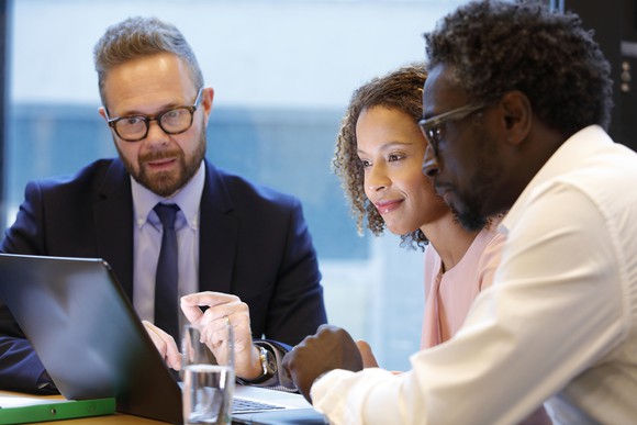 A couple consults with their banker at a conference table. 