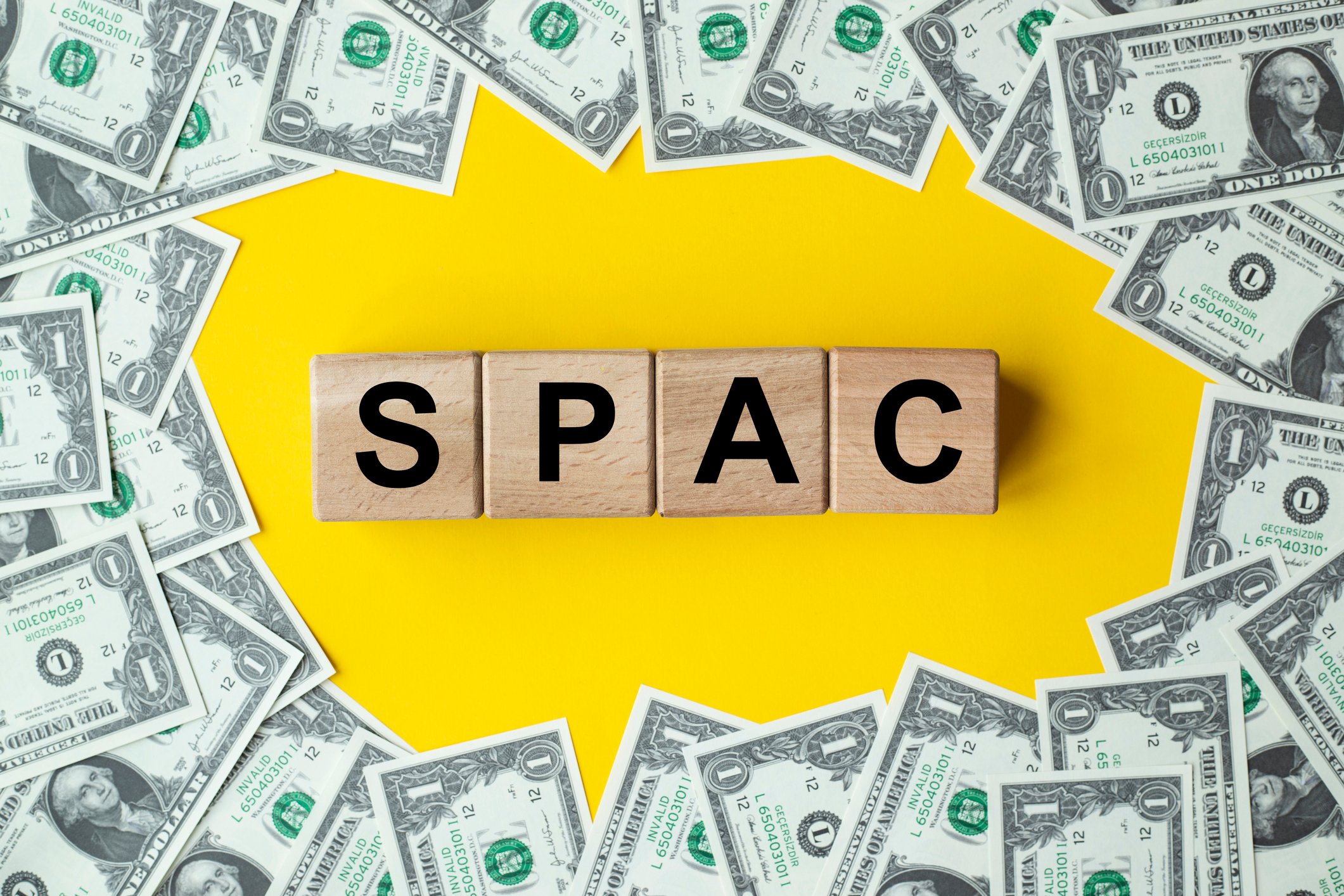 Blocks spelling 'SPAC' surrounded by dollars.