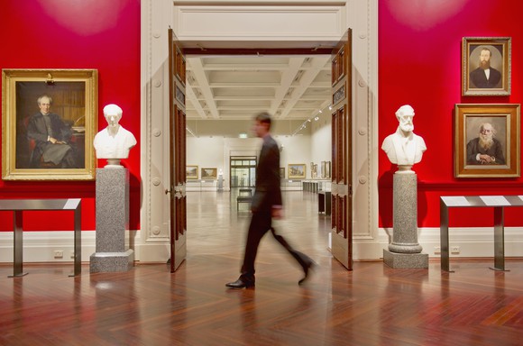 A security card walks through an art museum. 