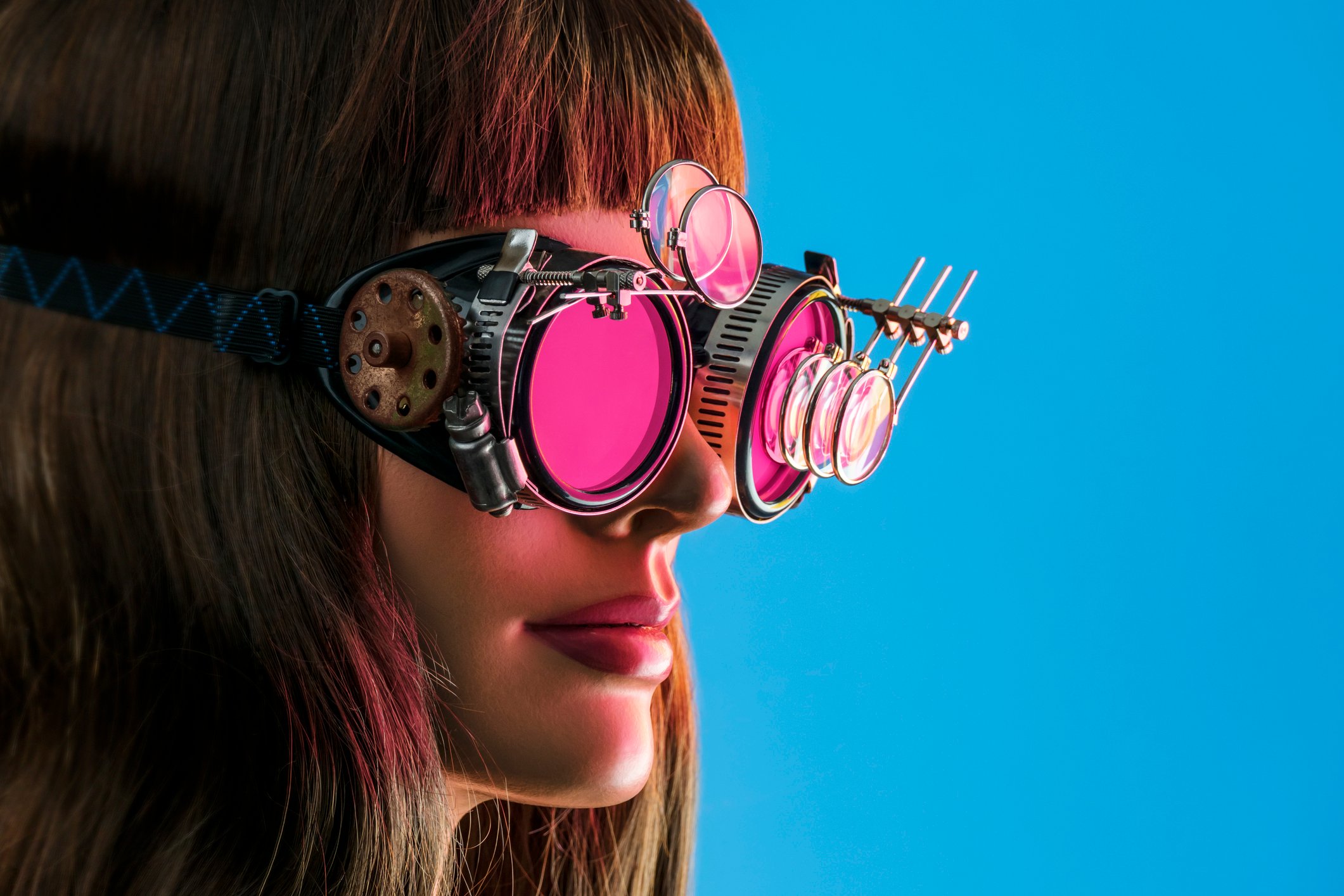 A woman wears a pair of futuristic steampunk glasses.