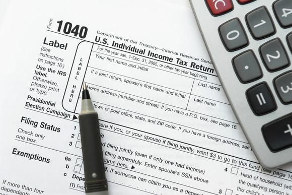 IRS form 1040 with a pen and calculator.