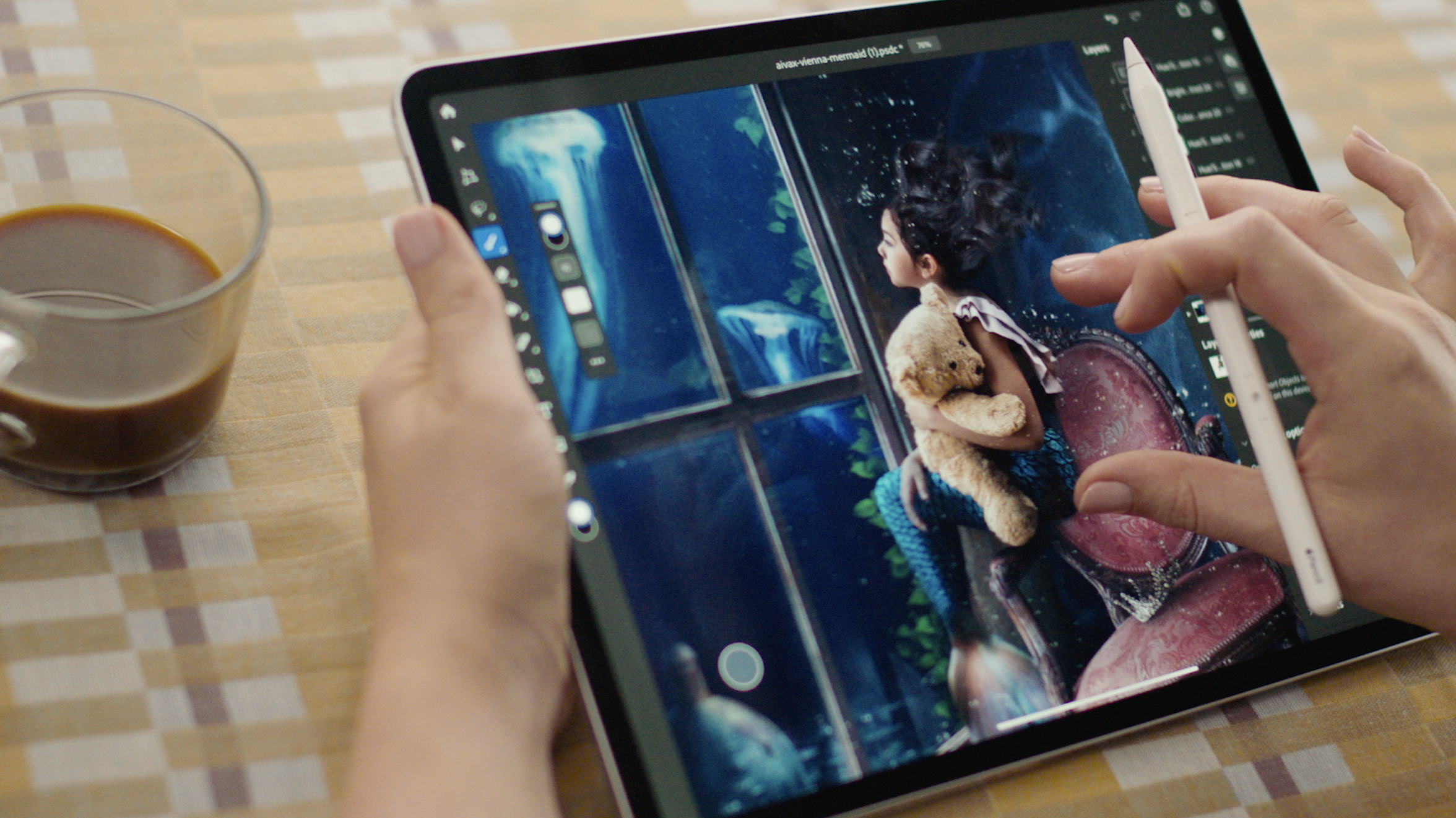 An artist working with Adobe Photoshop on a tablet.