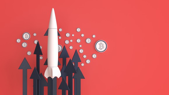 A rocket surrounded by Bitcoin logos.