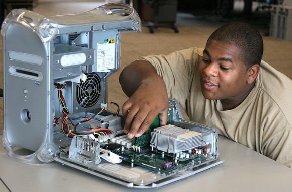 Technician placing memory chips inside of a PC.