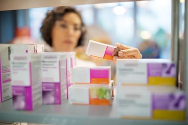 female pharmacist checking medicines on rack