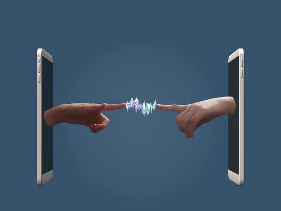 Two hands pop out of two smartphones facing each other and their fingers touch with electrical currents between them. 