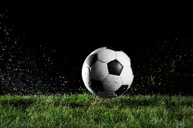 a soccer ball on wet grass at night