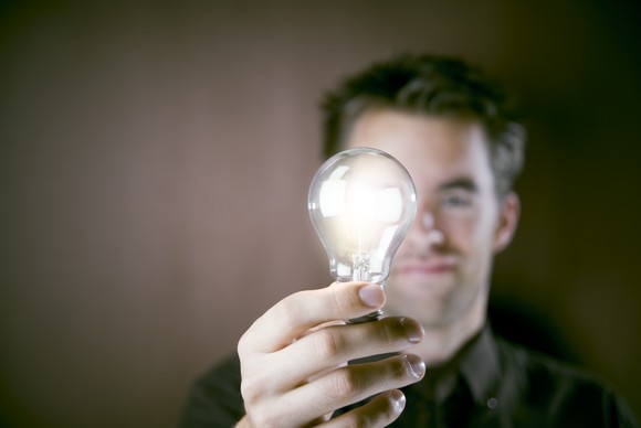 Man holding a lit lightbulb  