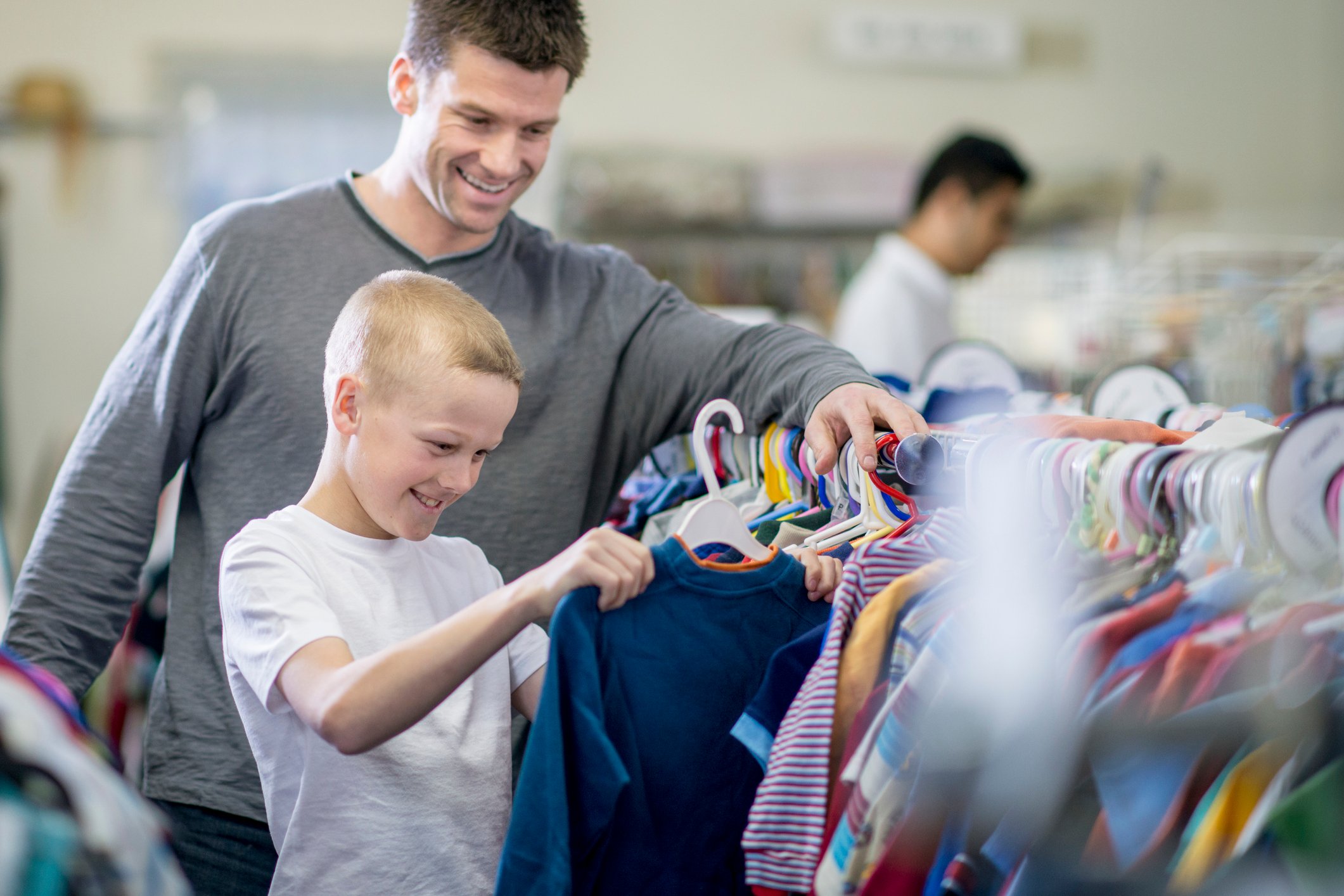 A man and child looking at shirts.