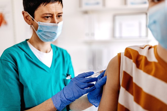 Healthcare worker giving a vaccine to a young boy