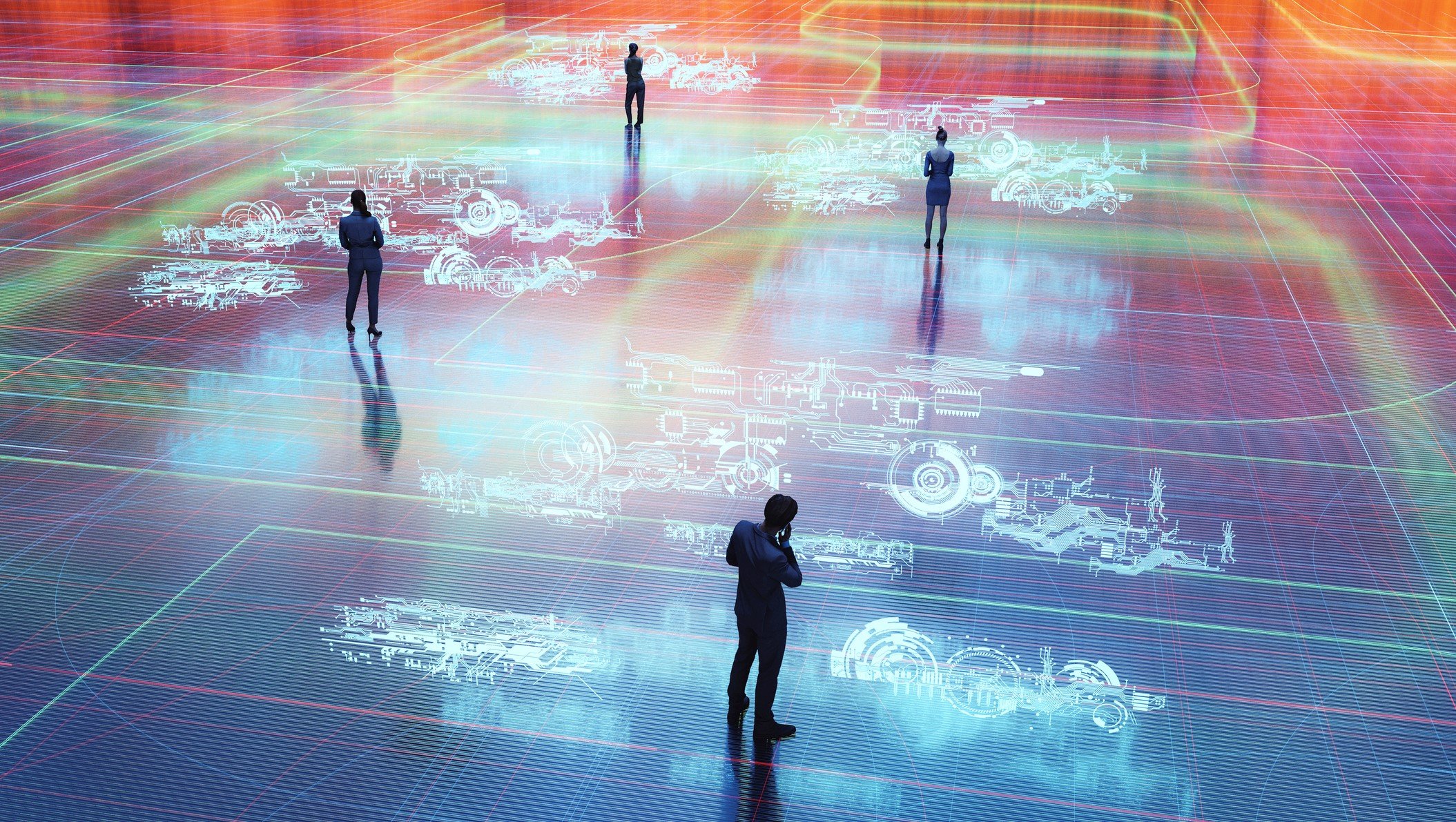 Four people standing in a space with the floor lit up with images of machinery