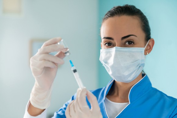 A nurse prepares a dose of coronavirus vaccine.
