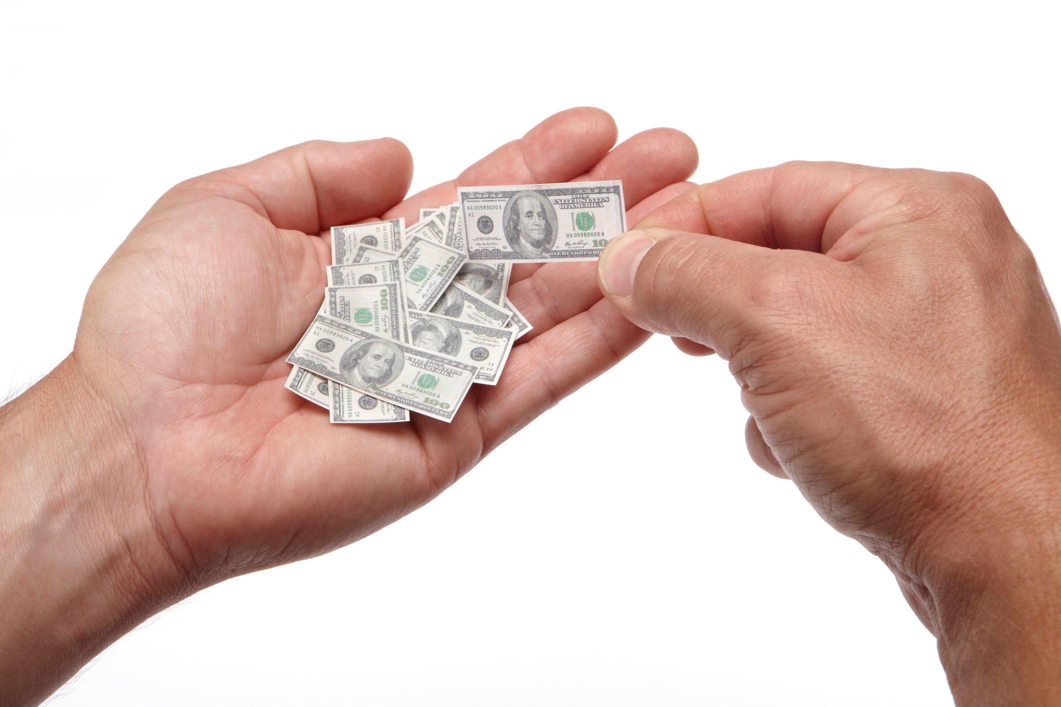 Several tiny U.S. $100 bills in a person's hand. 