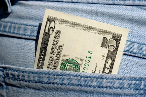 A five dollar bill in a jeans pocket.