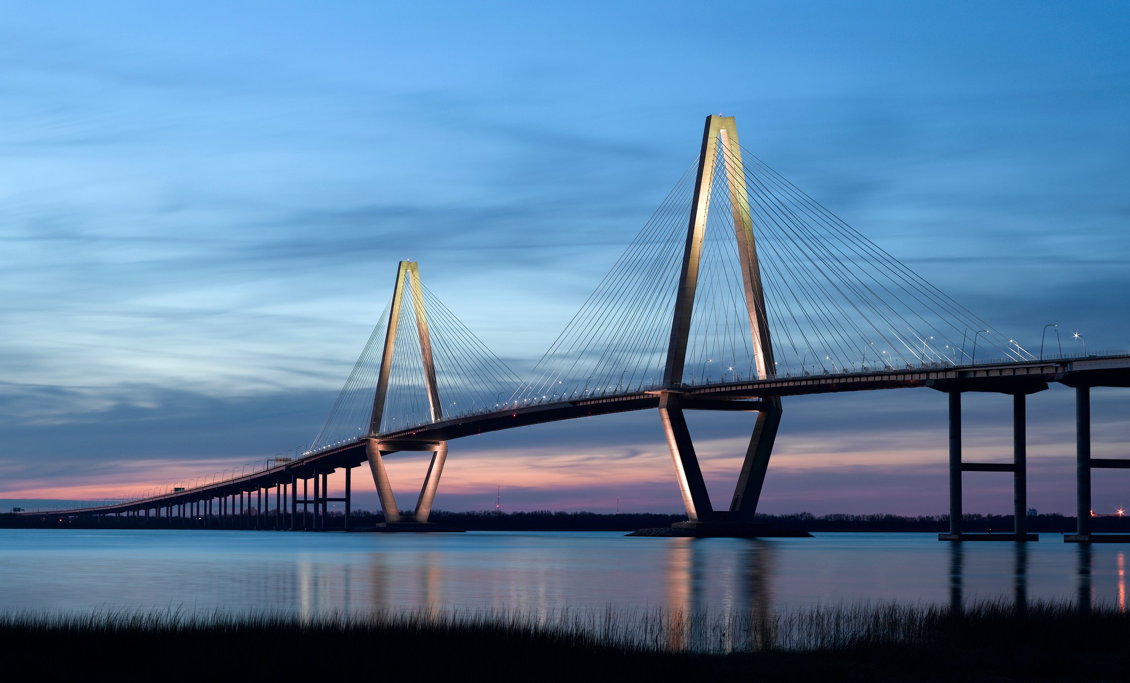 A bridge over a body of water at twilight.