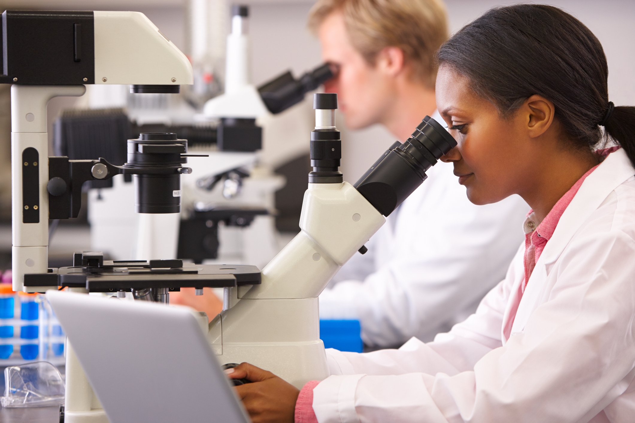Scientists looking through microscopes
