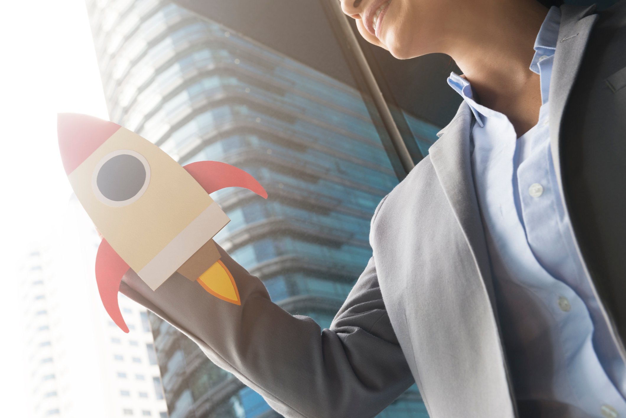 A woman holding a rocket ship cutout.