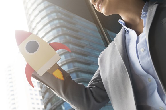 A woman holding a rocket ship cutout.