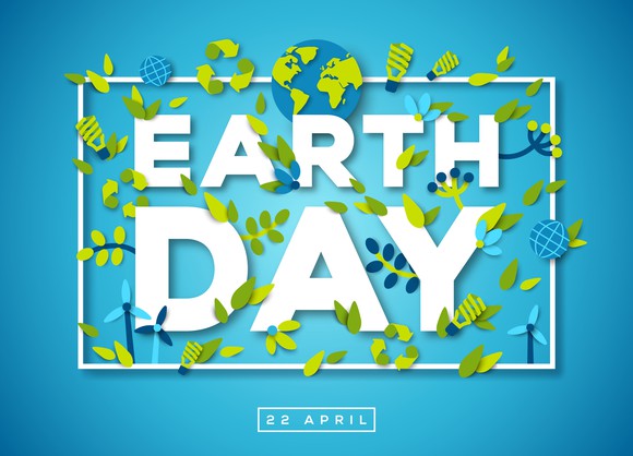 The words Earth Day on blue background with earth image and green leaves 