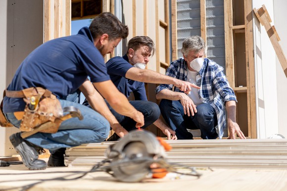 Construction crew looking at a new home's foundation. 