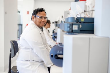 male-researcher-in-white-coat-sits-in-lab