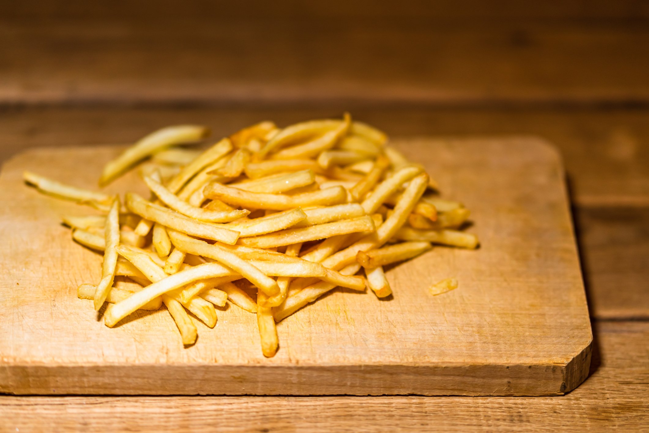 French fries on a cutting board. 