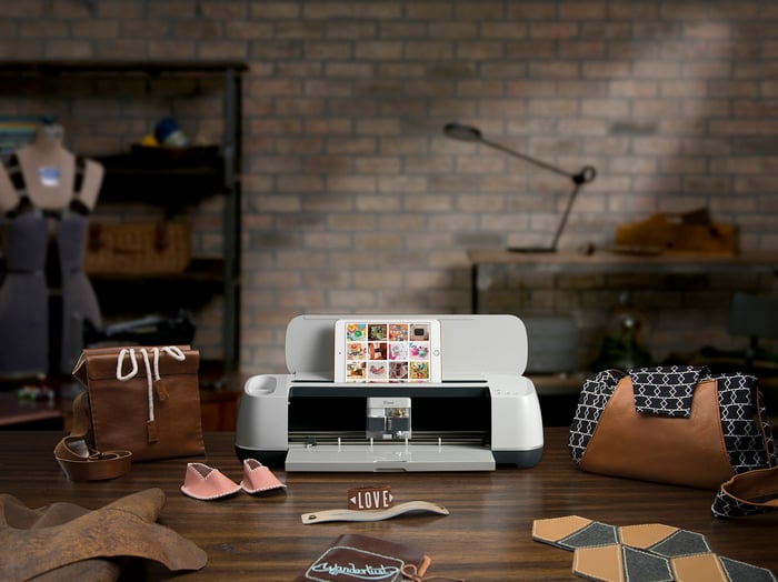 Cricut Maker surrounded by crafting supplies