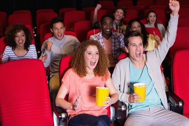 Small audience cheering in a movie theater