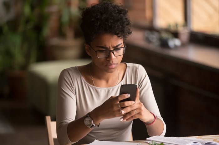 Frustrated woman looking at phone screen