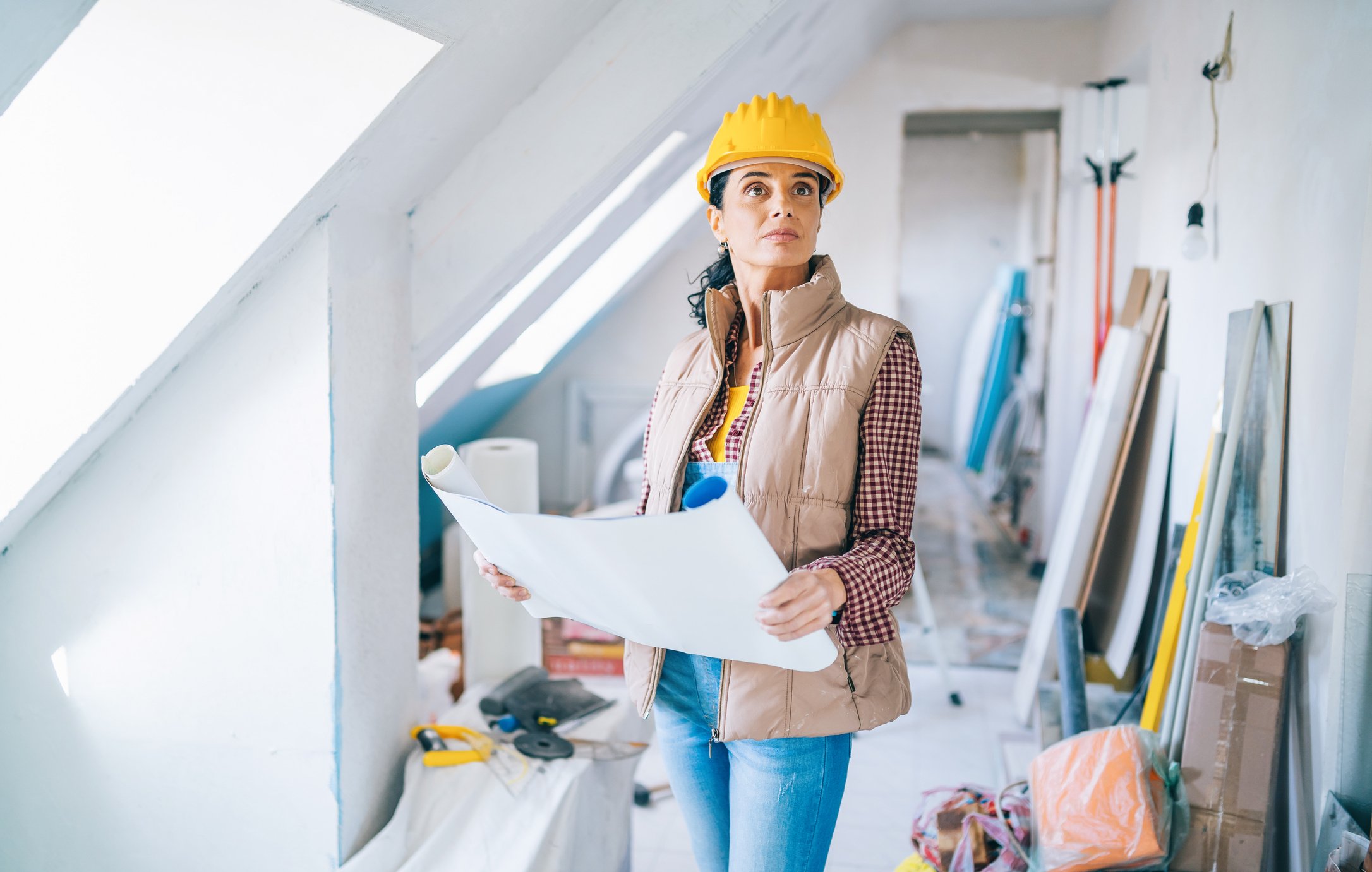 professional contractor on site at a home wearing a yellow hard hat looking around