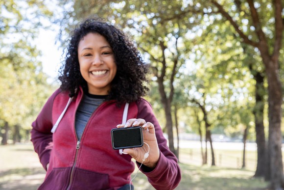 Woman jogging with continuous glucose monitor. 
