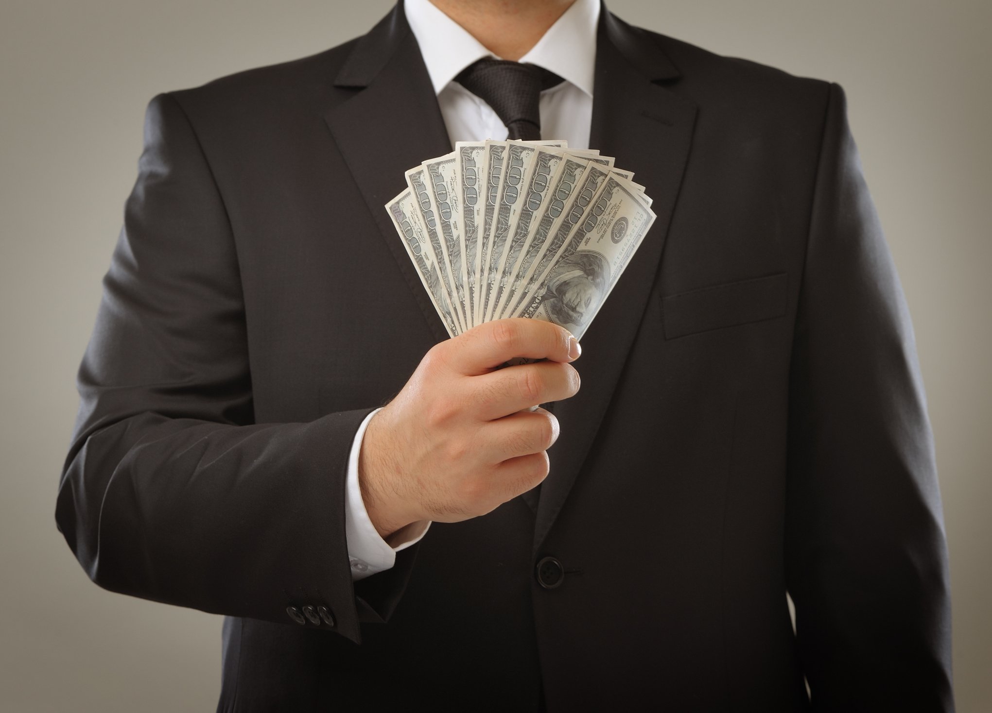 man holding $1000 in cash