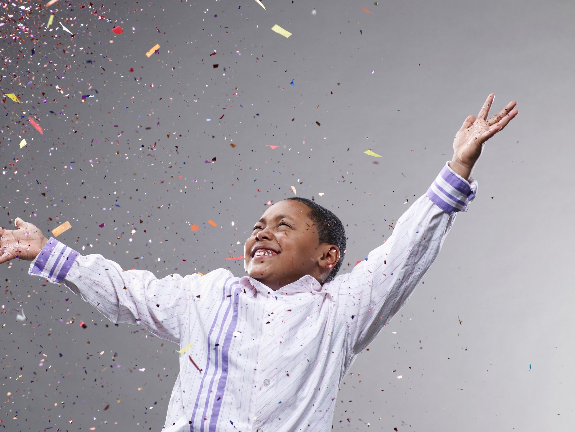 A child celebrates as confetti rains down.