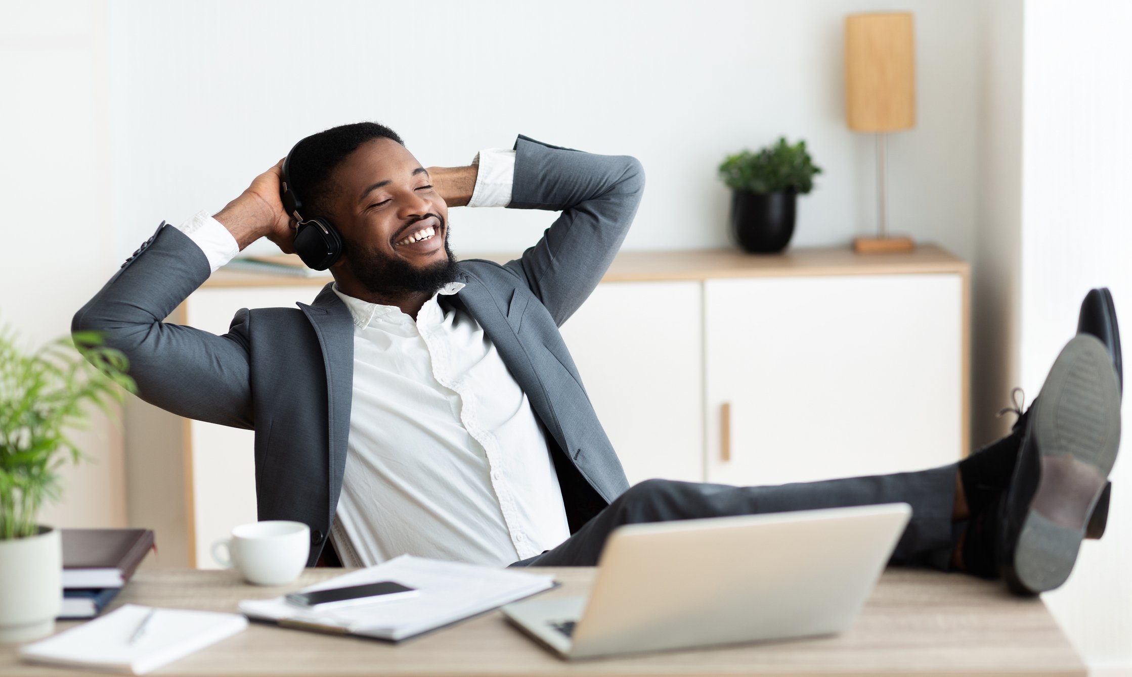man sitting back and smiling at his desk