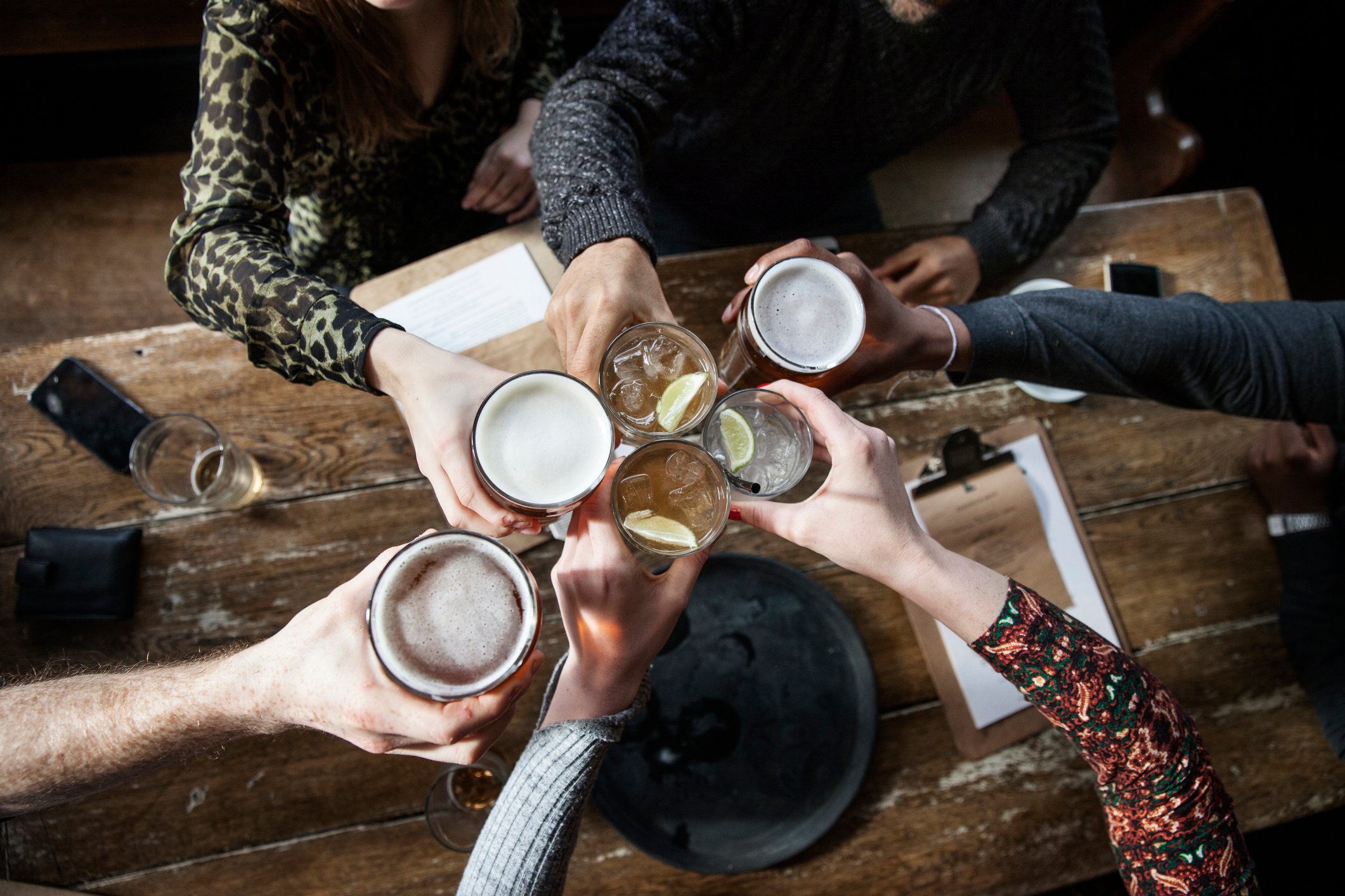 A group of people clinks glasses at a restaurant.