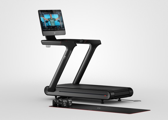 A Peloton Tread+ treadmill with a video screen showing a fitness instructor.