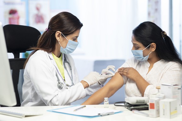 Doctor giving patient coronavirus vaccine.