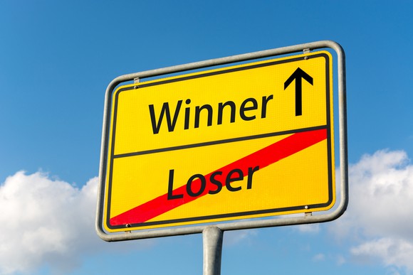 Sign showing winner next to an arrow pointing up above loser with a red slash through it
