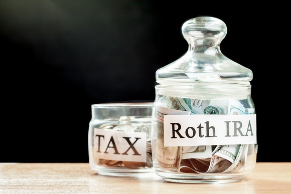 Roth IRA money jar next to a small tax money jar. 