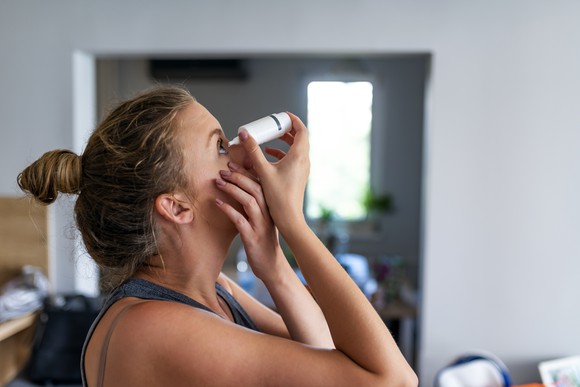 Woman applying eye drops