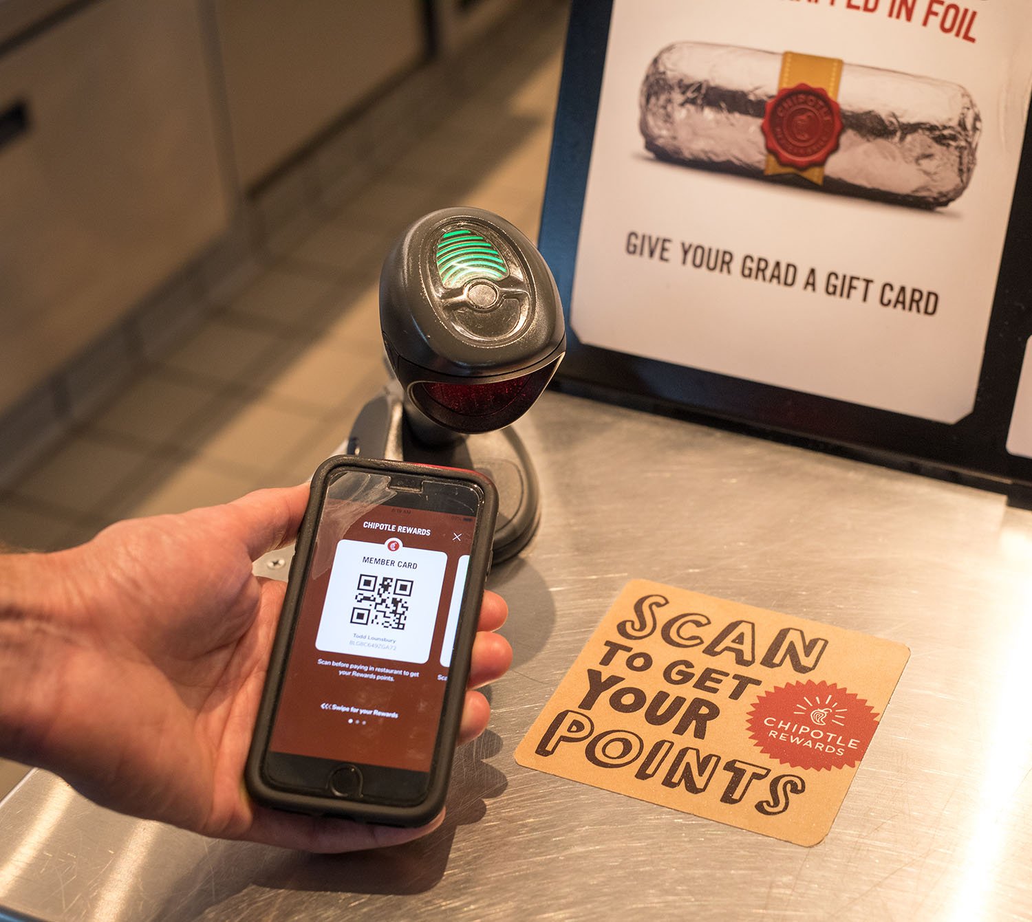 Someone scanning Chipotle rewards on phone in Chipotle restautant