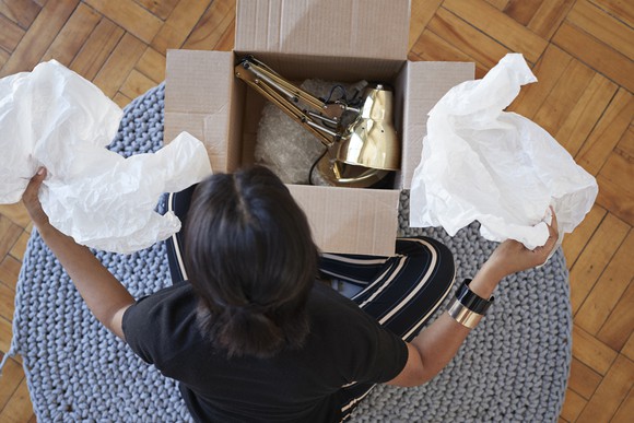 A person opening a box with a lamp in it