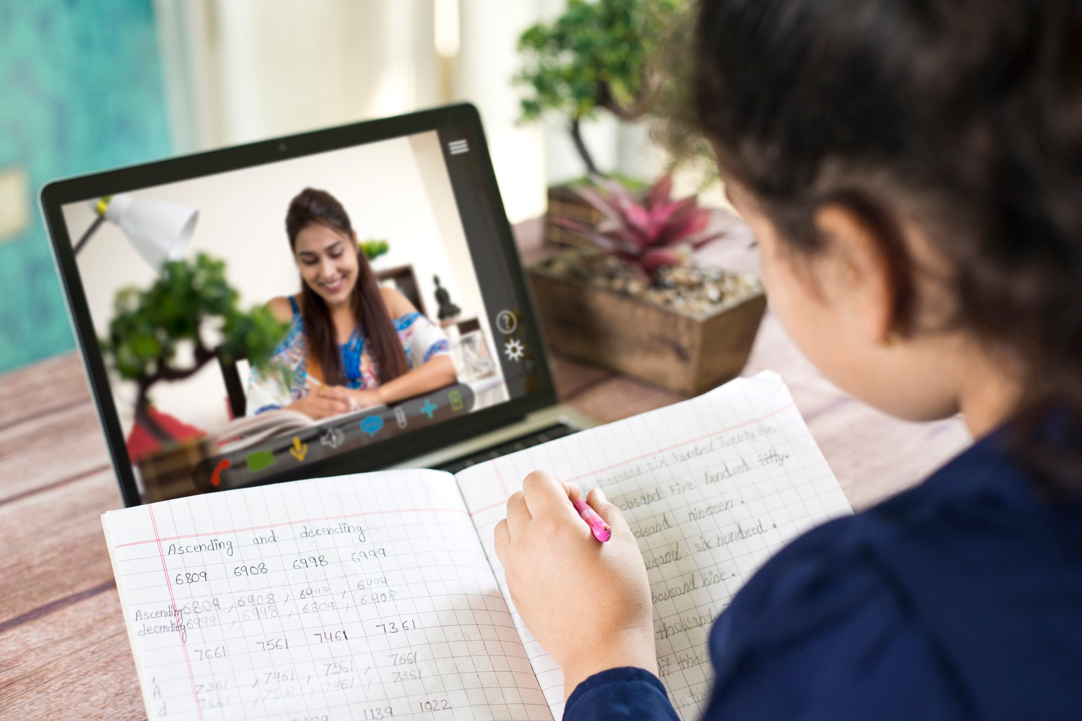 A child studying online on a laptop.