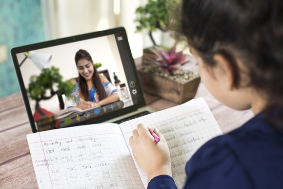A child studying online on a laptop.
