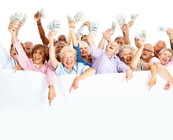 A group of elderly people holding wads of money in their hands and smiling.